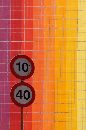 circular red and white 40 km per hour speed limit and weight not to exceed 10 metric tons in black numbers