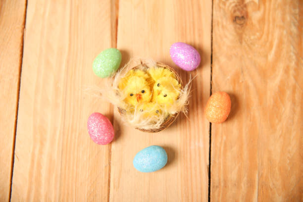 nest with yellow chickens and Easter patterned eggs. Decoration for Easter on a wooden background