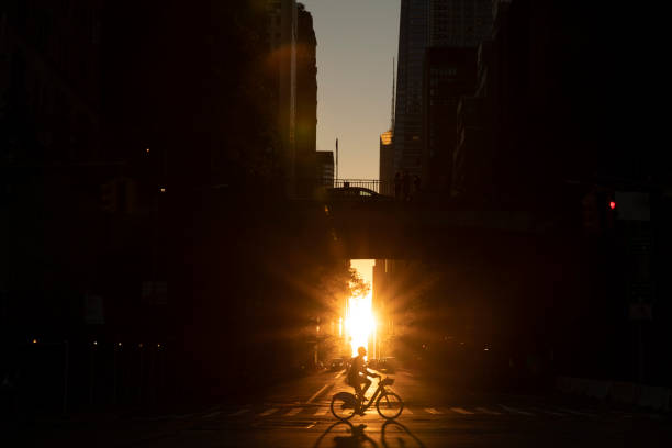 Manhattan Sunset Bicycle Ride Man riding bicycle across midtown Manhattan during sunset. 42nd street photos stock pictures, royalty-free photos & images