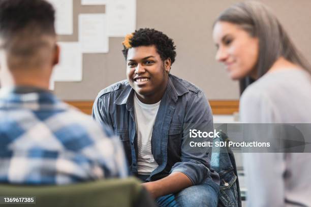 Unrecognizable Teacher Smiles As Teen Welcomes New Student Stock Photo - Download Image Now