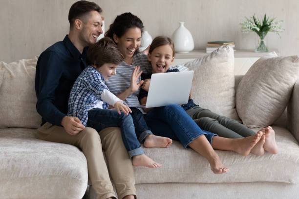 istock Happy parents with two kids making video call together 1369617620
