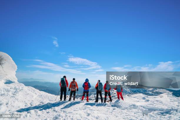 Mountain Alpine Climbing Team Is Watching The Scenery In High Altitude Mountain Peak In Winter Stock Photo - Download Image Now