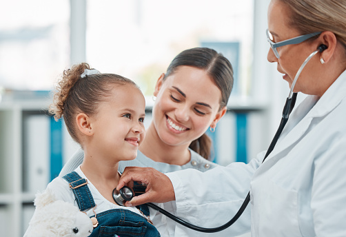 Foto de un médico examinando a una niña con un estetoscopio en una clínica photo