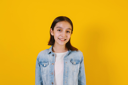 Portrait of latin child girl on yellow background in Mexico Latin America
