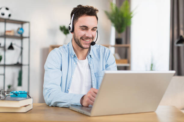 istock Man in headset having video call on laptop at home 1369620852