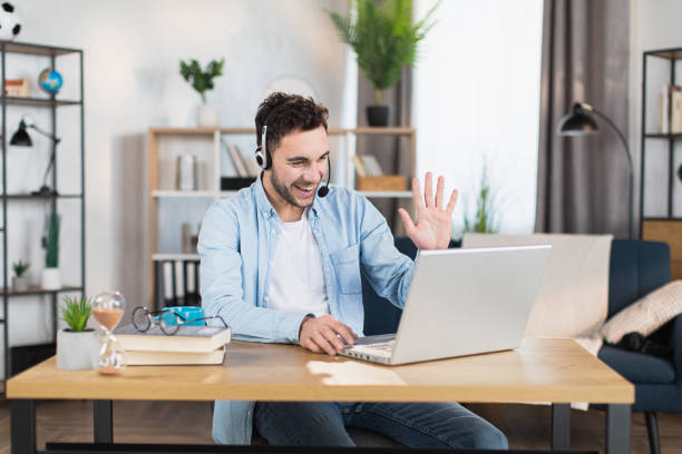 istock Man in headset having video conference on modern laptop 1369620865