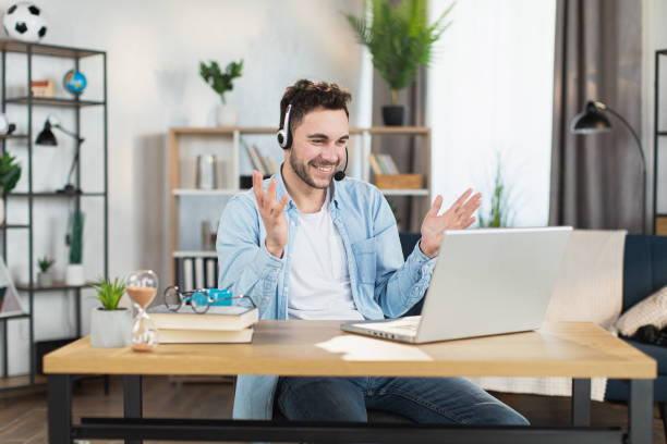 istock Man in headset having video conference on modern laptop 1369620885