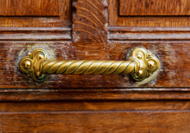 manija de puerta vieja en puerta vieja de madera marrón. de cerca parís, francia. detalles de latón dorado en una antigua puerta de madera. manija en la vieja puerta vintage de madera vieja marrón en mal estado - ancient past antique close up fotografías e imágenes de stock