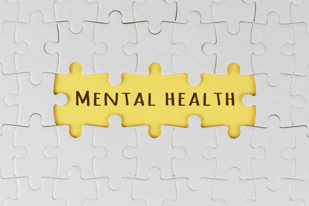 istock Mental health. White jigsaw puzzle with text on three missing pieces on soft yellow. 1369623460