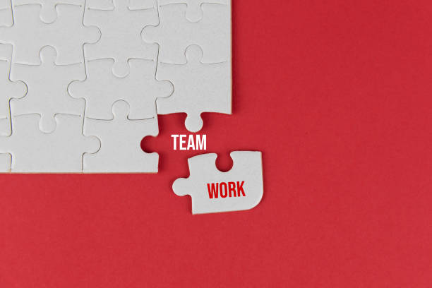 istock White jigsaw puzzle with missing piece on red with text - Team Work. Business concept. 1369624302