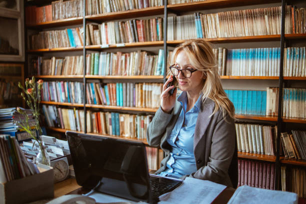 una mujer de mediana edad en una biblioteca - professor librarian university library fotografías e imágenes de stock