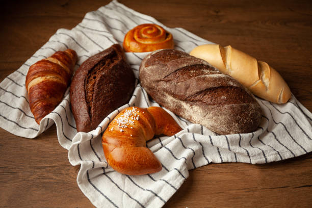 istock Assortment of bread pastries on a towel. Fresh buns on table. 1369627819
