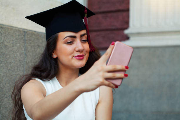 istock Happy graduate girl taking a selfie 1369630246