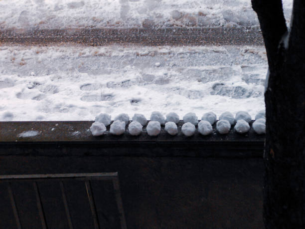 um monte de bola de neve posicionado em uma parede em uma fileira perto de uma estrada - apres ski winter friendship ski - fotografias e filmes do acervo