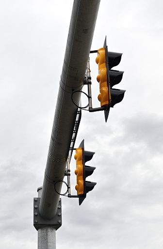 Traffic signals on pipe on cloudy day.