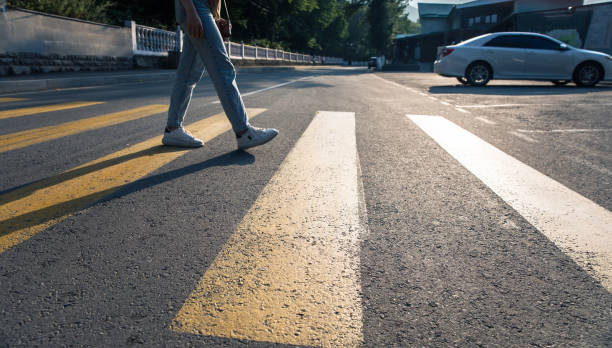 istock woman legs walking on crosswalk 1369638294