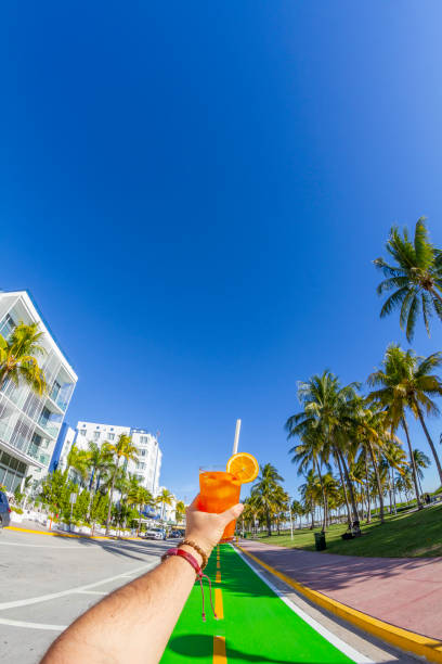 pov point de vue d’un jeune homme de voyage profitant de ses vacances tout en buvant un cocktail devant ocean drive, south beach, miami beach, miami, floride du sud, états-unis d’amérique - colony photos et images de collection