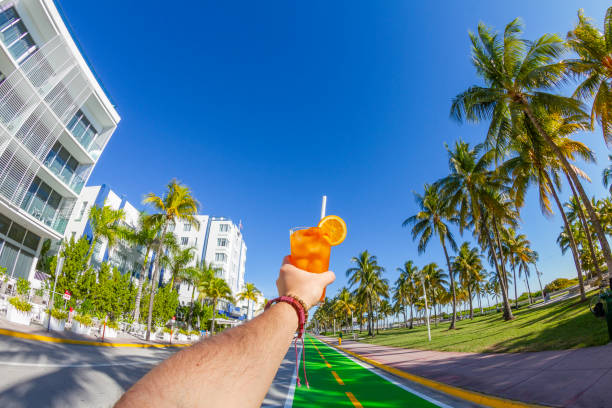 pov point de vue d’un jeune homme de voyage profitant de ses vacances tout en buvant un cocktail devant ocean drive, south beach, miami beach, miami, floride du sud, états-unis d’amérique - colony photos et images de collection