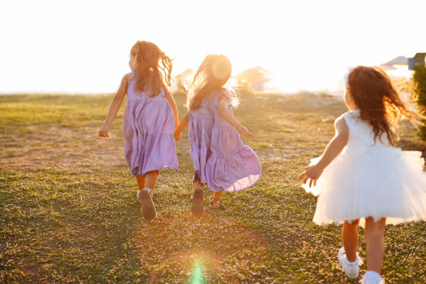 istock Three little girls having fun and running together 1369639854