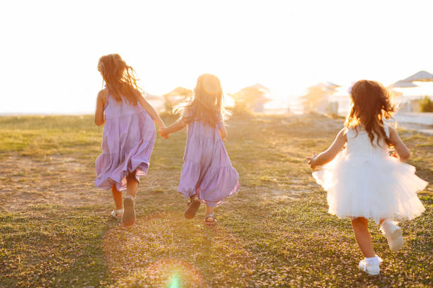istock Three little girls having fun and running together 1369639895