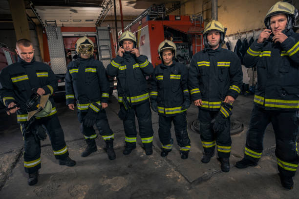 istock Portrait of firefighters standing by a fire engine. 1369642398