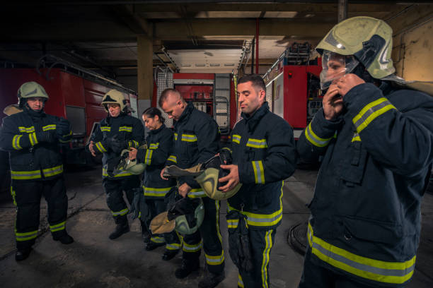 istock Firemen preparing for emergency service. Firefighters putting on gloves. 1369642472