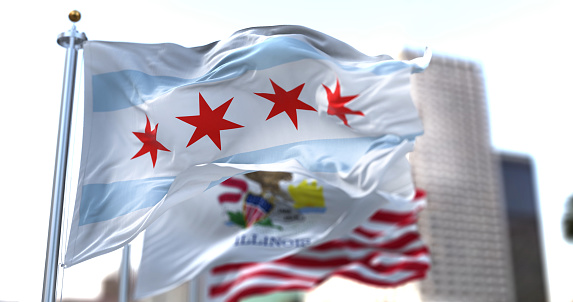 Chicago city flag waving in the wind with Illinois state and United States national flags blurred in background