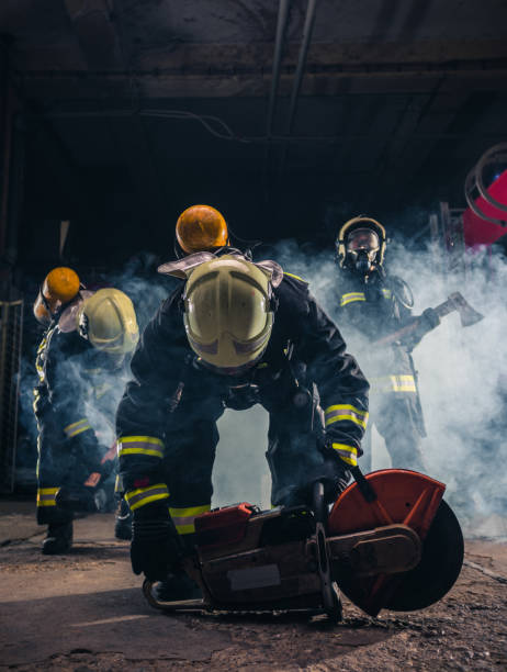 istock Group of three young fireman posing inside the fire department with uniform and tools 1369643980