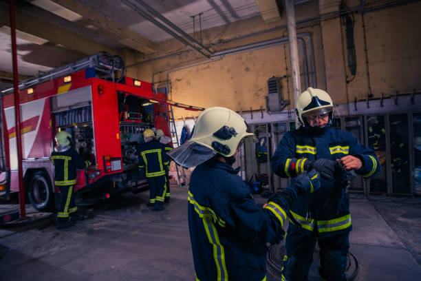 istock Firefighters preparing their uniform and the firetruck in the background inside the fire station 1369644937