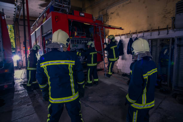 istock Firefighters preparing their uniform and the firetruck in the background inside the fire station 1369644955