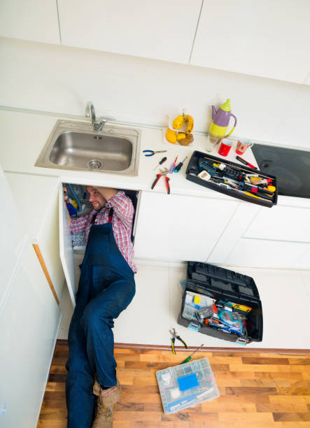 istock Handyman Lying On Floor Repairing Sink In Kitchen 1369645406