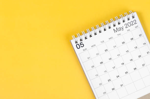 istock May 2022 desk calendar on light yellow background. 1369645446