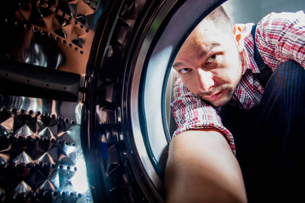 istock Plumber repairing laundry machine in bathroom 1369645584