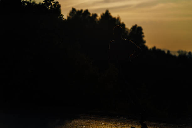 istock Male silhouette running in mountains under sunlight 1369646340
