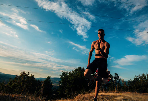 istock Man silhouette running in beautiful nature while carrying parachute for resistance 1369646344