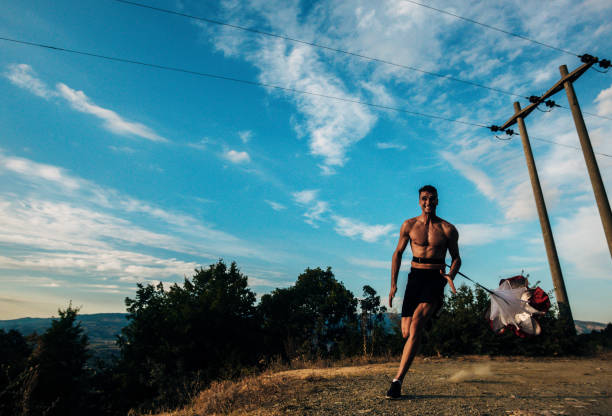 istock Muscular silhouette fit sport model sprinter exercising sprint at mountain 1369646346