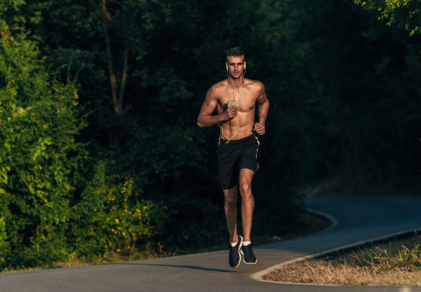 istock Sporty shirtless man jogging with mobile in his hands 1369646350