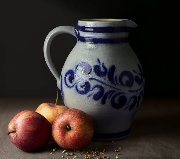 istock Still life, with jug, red apples and grain on table with tablecloth and atmospheric light 1369646550