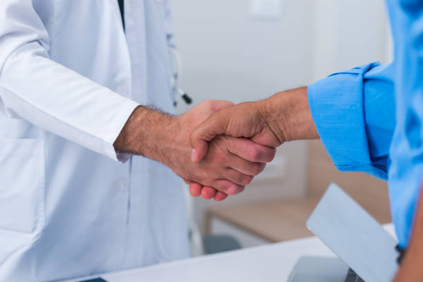 istock Handshake between a doctor and his senior ( old ) patient. 1369646646