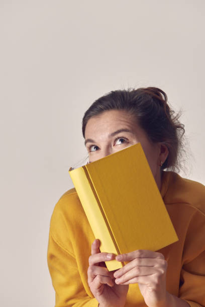 istock A beautiful, mysterious woman with a yellow book. 1369652206