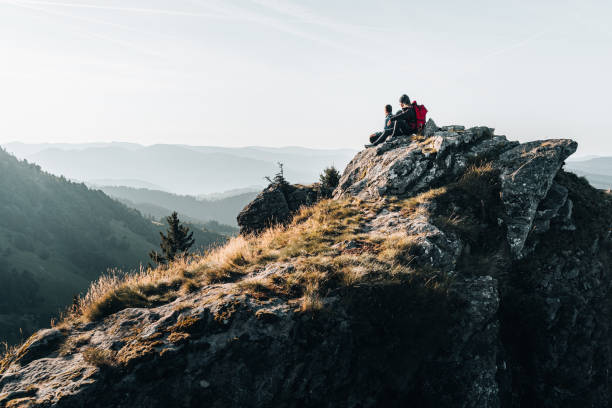 istock Young couple with backpacks relax on a mountain summit 1369652285