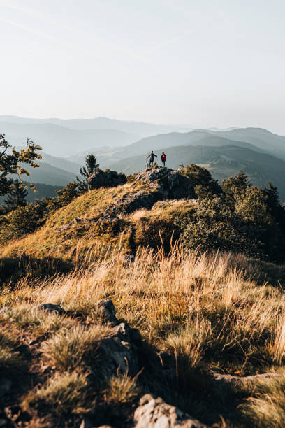 junges paar mit rucksäcken entspannt auf einem berggipfel - tranquil scene joy vacations high angle view stock-fotos und bilder