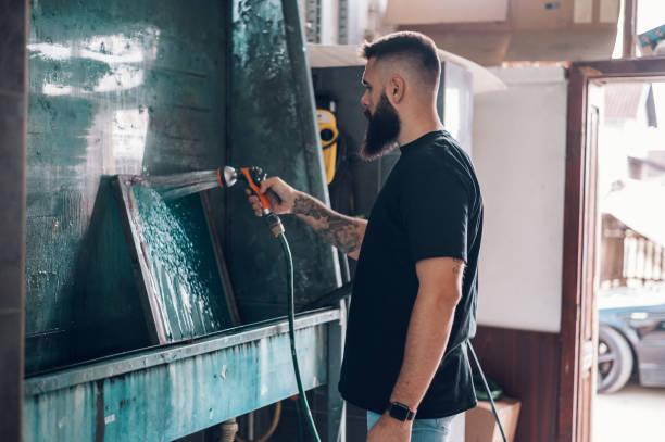 istock Male worker cleaning frame with water in a printing workshop 1369652702