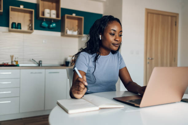 istock Young african american woman working from home and using a laptop 1369652736
