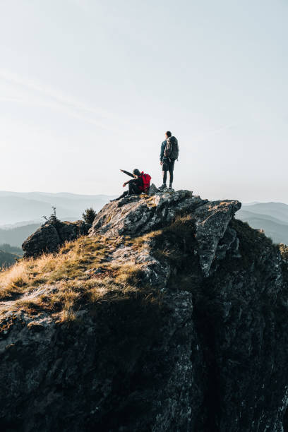 istock Young couple with backpacks relax on a mountain summit 1369652852