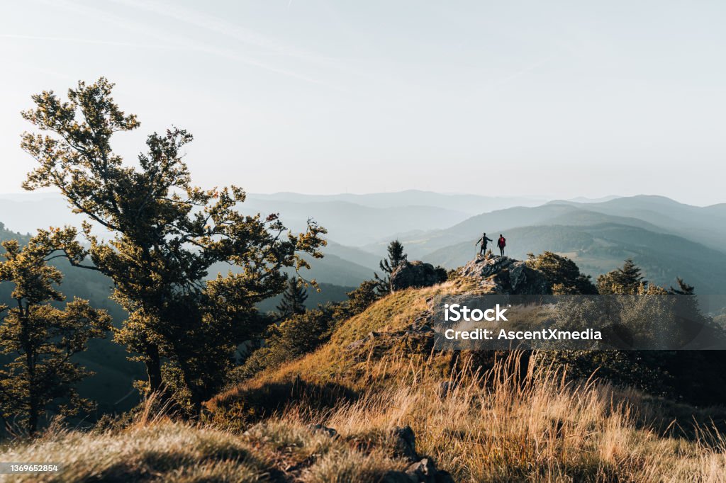 Young couple backpack up a mountain summit Above the Black Forest,  Baden-Württemberg Black Forest - Germany Stock Photo