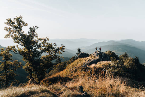 young couple backpack up a mountain summit - black forest imagens e fotografias de stock