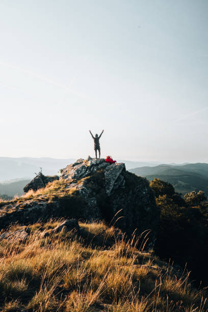 backpacker celebra en la cima de la montaña al amanecer - solitude mountain range ridge mountain peak fotografías e imágenes de stock