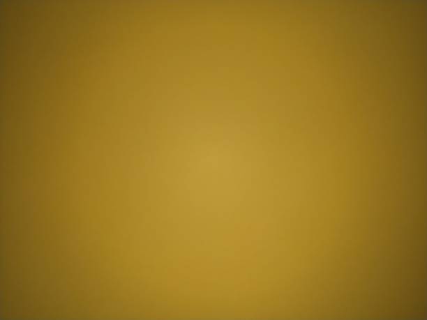 istock Ocher color background. Colored paper dimly lit in the middle. Light dark vignetting around the edges. The play of light and shadow. Can be used as background 1369653000
