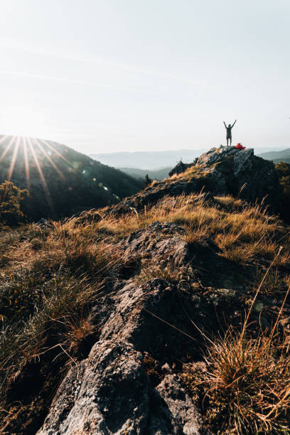 istock Backpacker celebrates on mountain summit at sunrise 1369653118